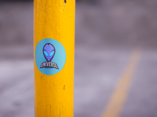 Round Sticker On A Yellow Pole In A Parking Lot Mockup Gaming